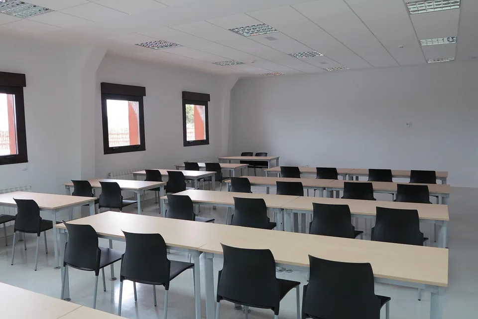 Salle de formation avec tables, chaises et espace de présentation