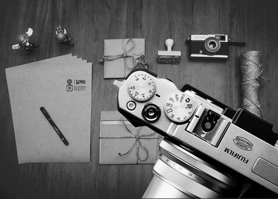 Appareil photo et matériel sur une table de travail, photographie d’illustration