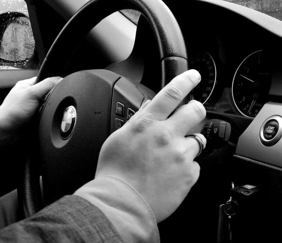 Mains au volant d’une voiture, photographie en noir et blanc