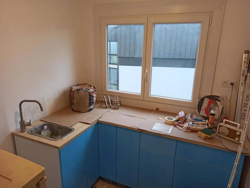 Petite cuisine en cours de rénovation avec meubles bleus