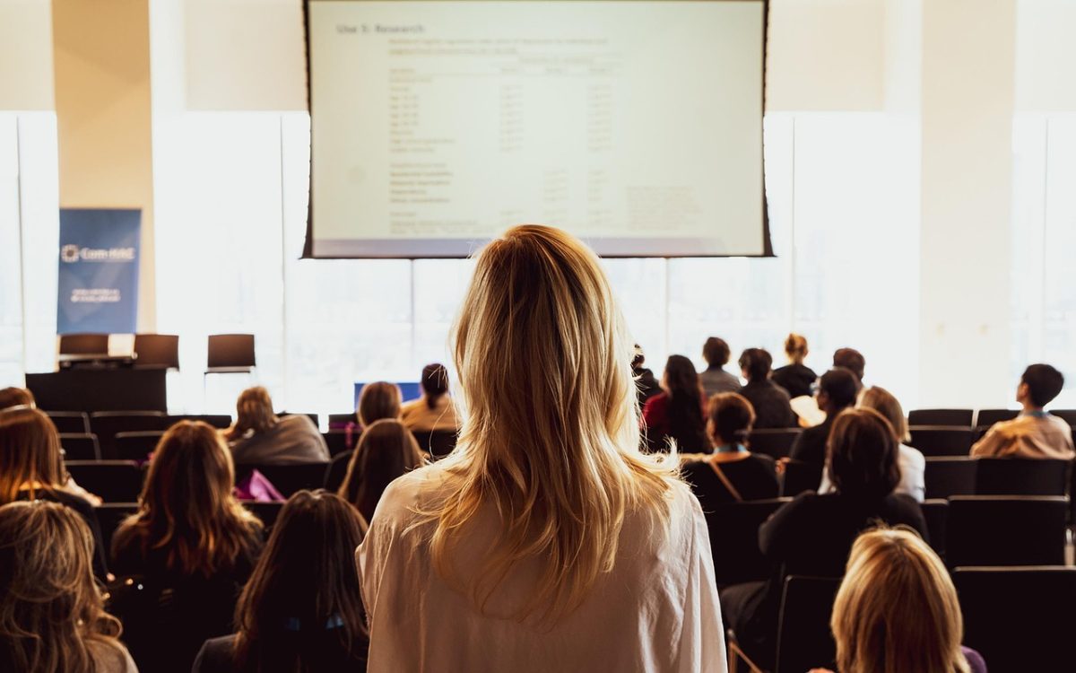 Public assis face à un écran de présentation lors d'une conférence professionnelle